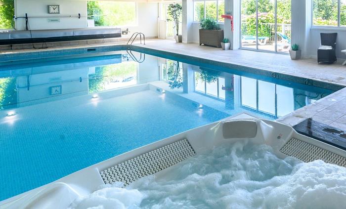 Relax after a long day in our indoor heated swimming pool and spa bath with views over the bay